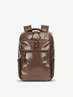 a brown backpack on a white background with the word calm written in black and gold