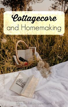 an open book sitting on top of a white blanket next to a basket filled with flowers