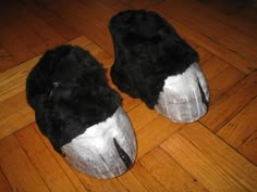 two pairs of black and white slippers sitting on top of a hard wood floor