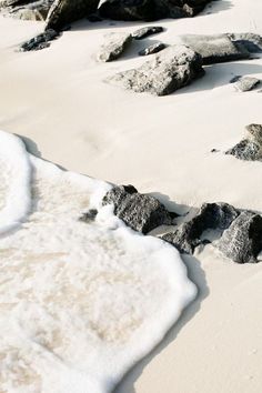 some rocks and snow on the beach