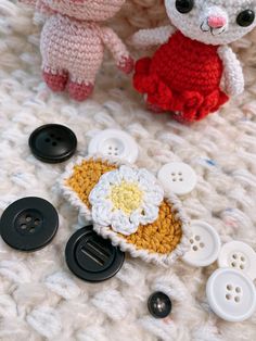 two crocheted teddy bears sitting next to each other on top of a blanket