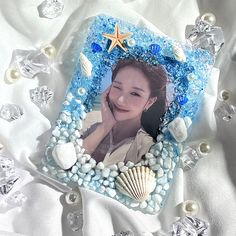 an image of a woman with seashells and starfish on her photo frame