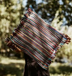 a woman carrying a multicolored blanket on her back