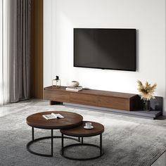 a living room with two coffee tables and a flat screen tv mounted on the wall