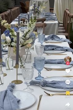 the table is set with blue linens and place settings for two people to sit at