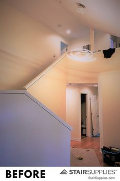 an empty room with stairs leading up to the ceiling and light fixture on the wall