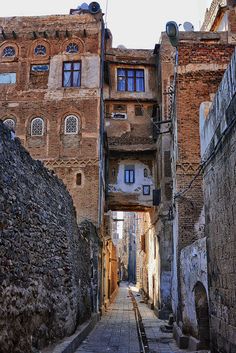 an alleyway between two buildings in the old city with cobblestone pavement and stone walls