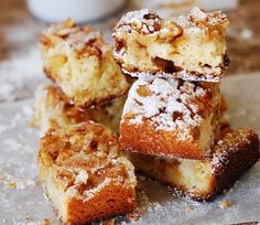 several pieces of cake are piled on top of each other with powdered sugar toppings