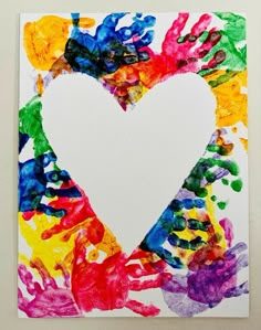 a heart made out of handprints on a piece of white paper with colorful paint