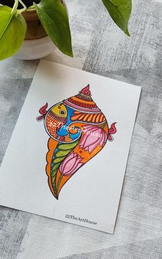 a card with an image of a fish on it next to a potted plant