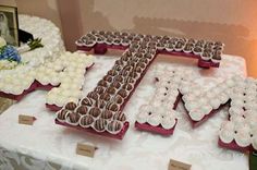 the table is covered with many different types of cakes and cupcakes that spell out the word love