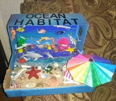 an open box with various items in it on a table next to a chair and wall