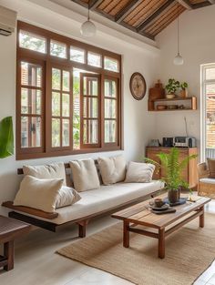 a living room filled with lots of furniture next to a large window covered in wooden shutters