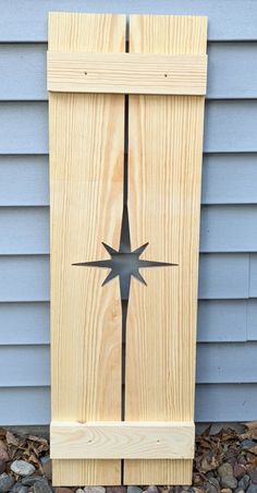 a wooden door with a star cut out of it on the side of a house