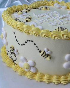 a birthday cake decorated with yellow frosting and white icing, topped with honeybees