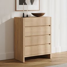 a wooden dresser sitting next to a white wall with a bowl on top of it