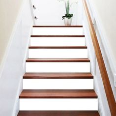 there is a vase with flowers on the top of some stairs in this house that has been painted white