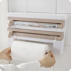 a person holding a roll of toilet paper in front of a wall mounted heater