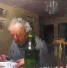 an old man sitting at a table with a bottle