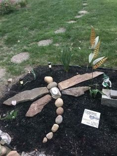 a cross made out of rocks and stones sitting on top of a black rock bed