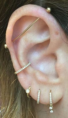 a woman's ear with three different types of piercings