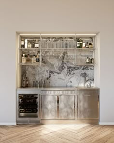 a kitchen with marble counter tops and stainless steel cabinets, along with wine glasses on the shelves