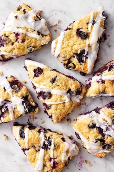 blueberry scones with white icing on a marble surface