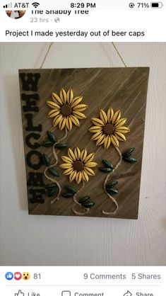 a wooden sign with sunflowers hanging from it's side on a wall