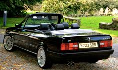 a black convertible car parked on the side of a road