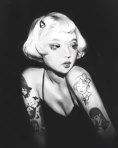 a black and white photo of a woman with tattoos