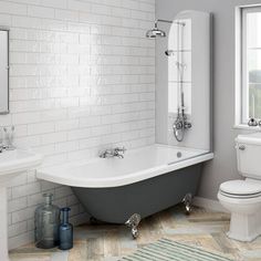 a bathroom with a claw foot tub, toilet and sink