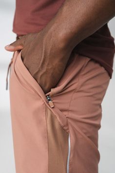 a man with his hand on the back of his pants that he is pulling up