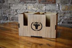 a wooden box with an image of a bull on the front and side, sitting on a table next to a brick wall