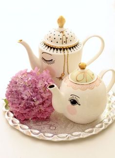 a tea set with pink flowers on a plate