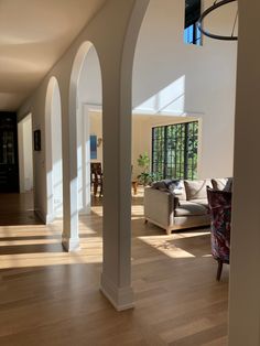 an open living room with white walls and wood flooring in the middle of it