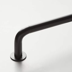 a black metal pipe on a white surface