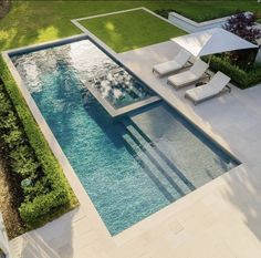 an aerial view of a swimming pool with lounge chairs