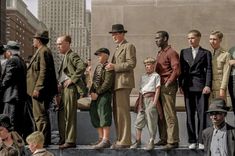 a group of men standing next to each other on top of a cement slab in front of tall buildings