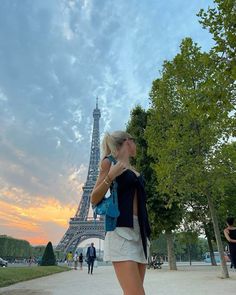 a woman standing in front of the eiffel tower