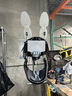 the back end of a snowboard hanging from a rack in a shop with other equipment