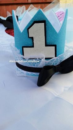 a blue birthday hat with the number one on it sitting on top of a table