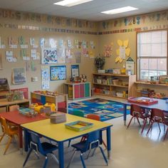 a classroom filled with lots of colorful tables and chairs