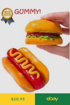 a hand holding a hot dog and a hamburger shaped like a burger with ketchup on it