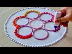 someone is using scissors and yarn to make a circular craft piece with circles on it