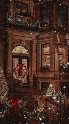 a house with christmas lights and wreaths on the front door