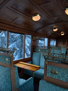 the inside of a train car with blue seats and wood trimming on the walls