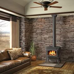 a living room with a couch, chair and fire place inside of it in front of a stone wall