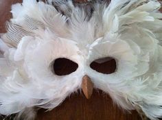 an owl mask made out of feathers on a table