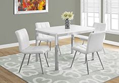 a white dining table with four chairs and a rug on the floor in front of it