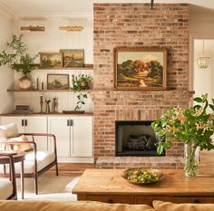 a living room filled with furniture and a fire place in front of a brick fireplace